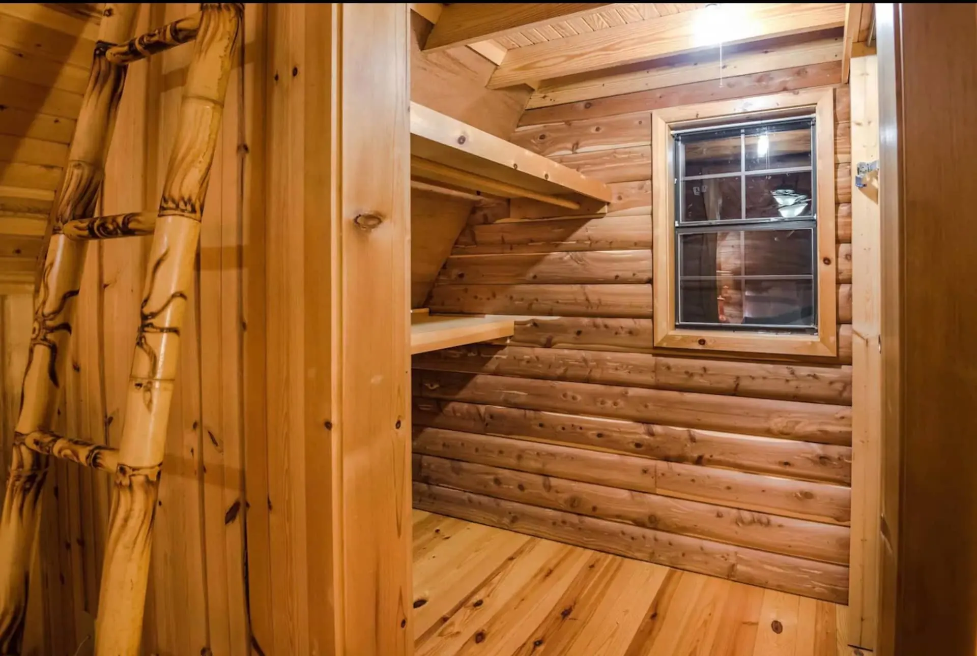 Cedar-lined closet with built-in shelving and a small window, just off the cabin bathroom